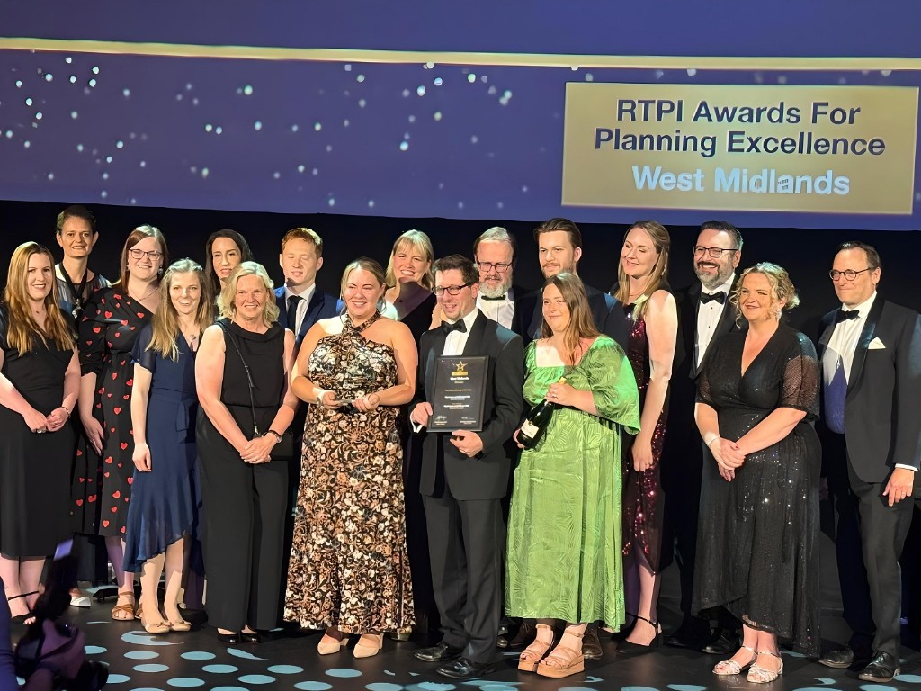 A group of people on a stage accepting an award