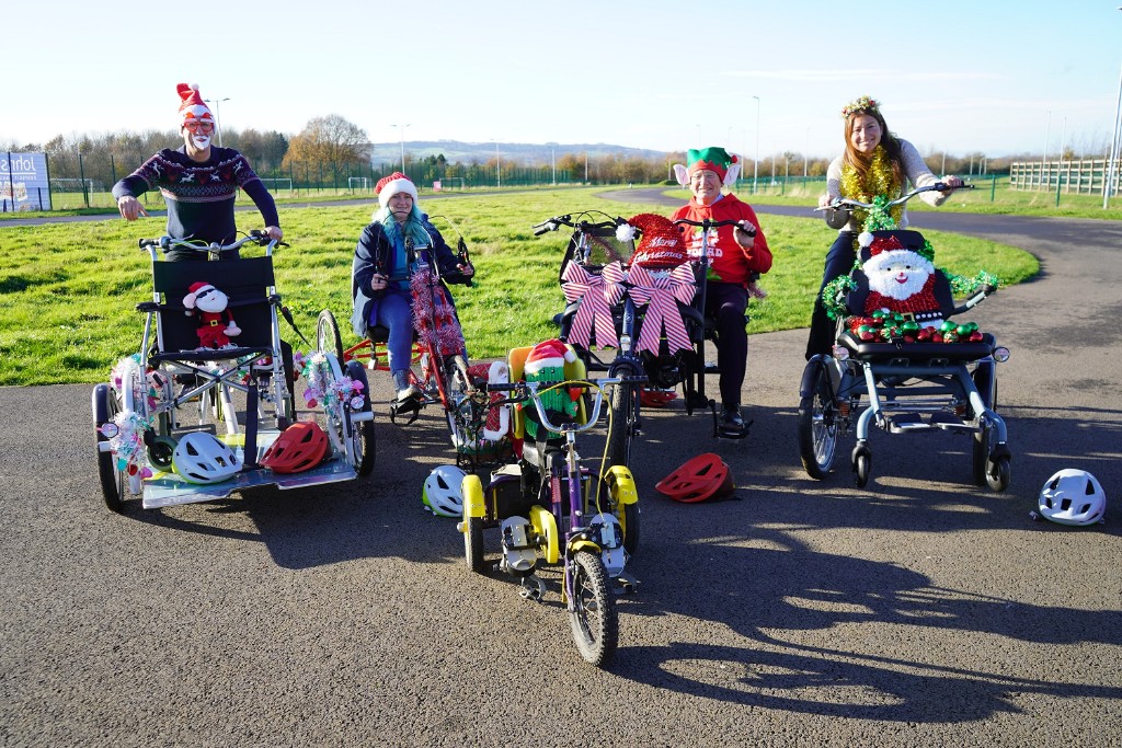 Four people on bikes dressed in Christmas gear.