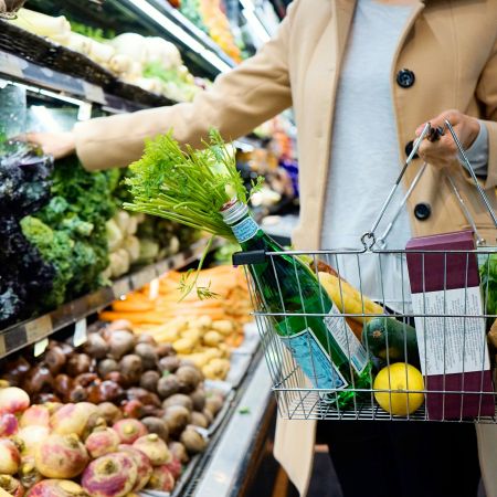 A lady picking vegetables in a supermarket