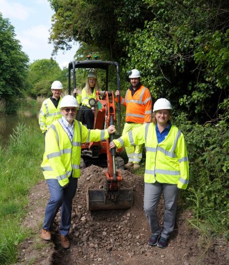 Five people stood around a digger